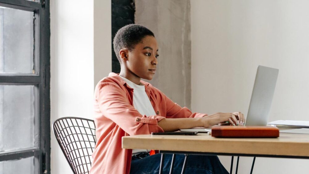 Person at a desk typing on a laptop.