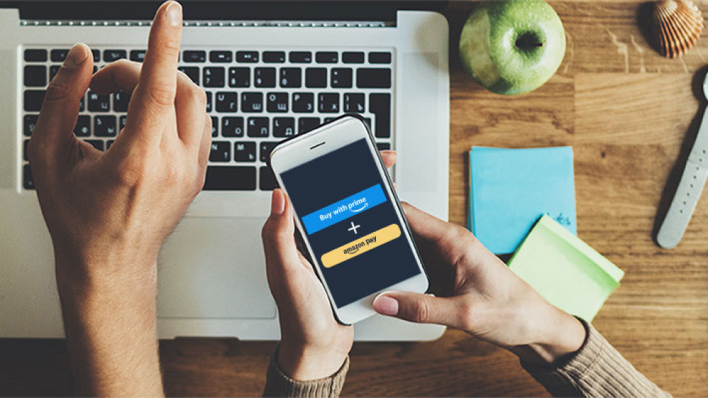 Top view of person's laptop with hand pointing to screen, and on a mobile device.