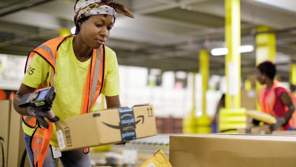 Worker in fulfillment center moving a box.