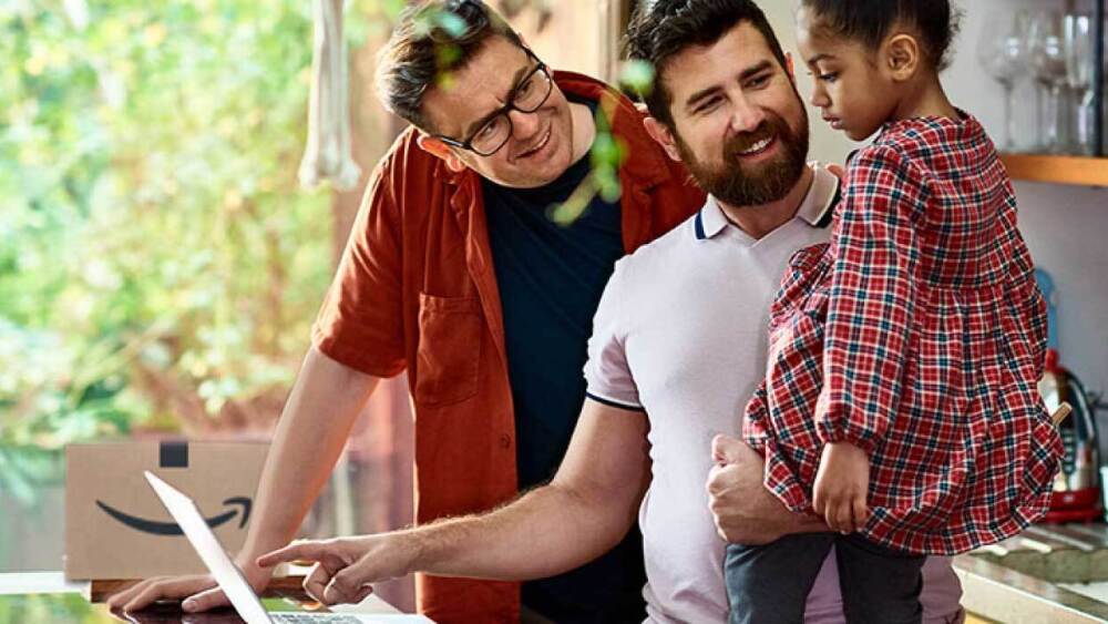 Family in kitchen around the computer.