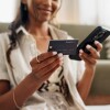 Closeup of individual with smartphone and credit card for online purchase