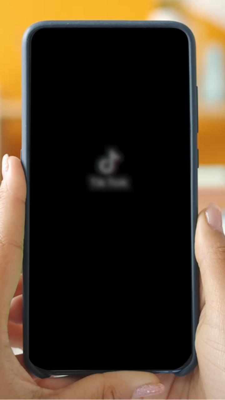 Woman holding phone featuring TikTok for Buy with Prime